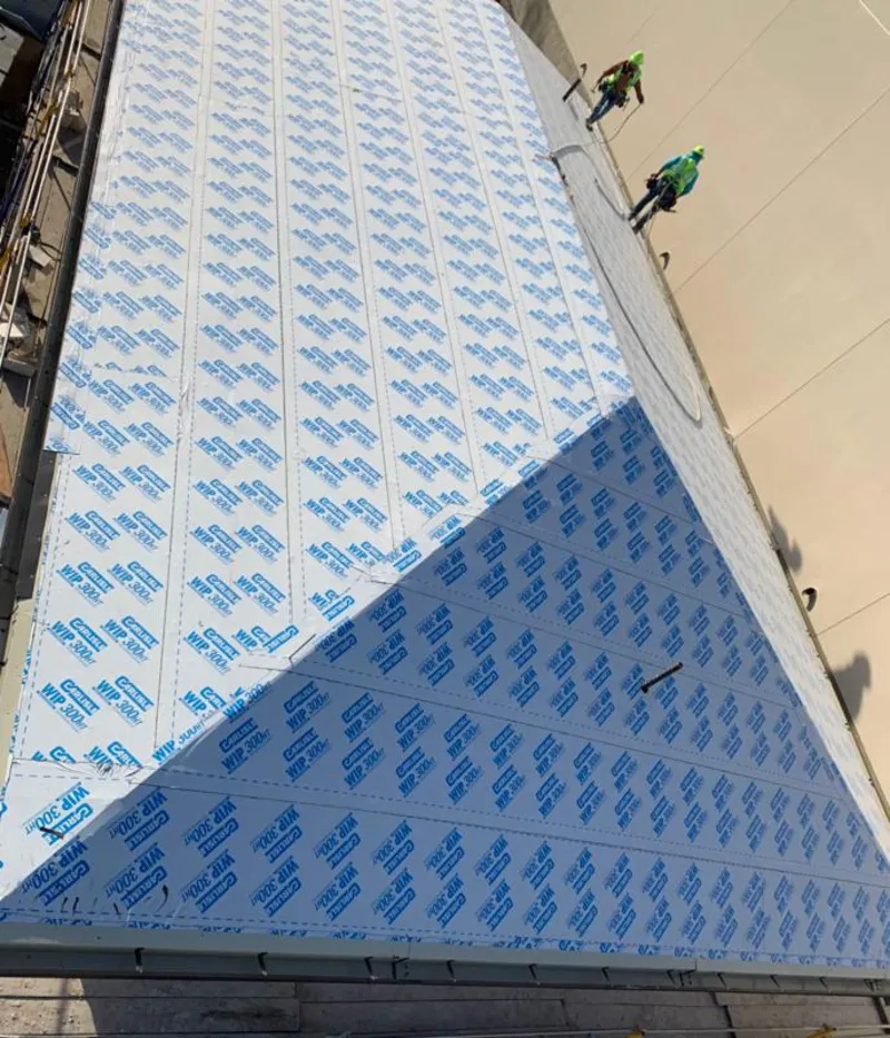 Professional roofers installing underlayment on a metal roof in Raritan